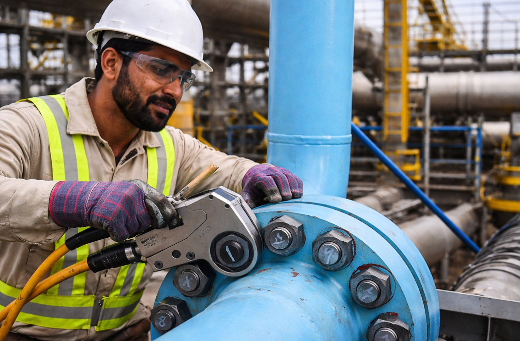 Hydraulic torque wrench tightening flange bolts in an oil and gas facility